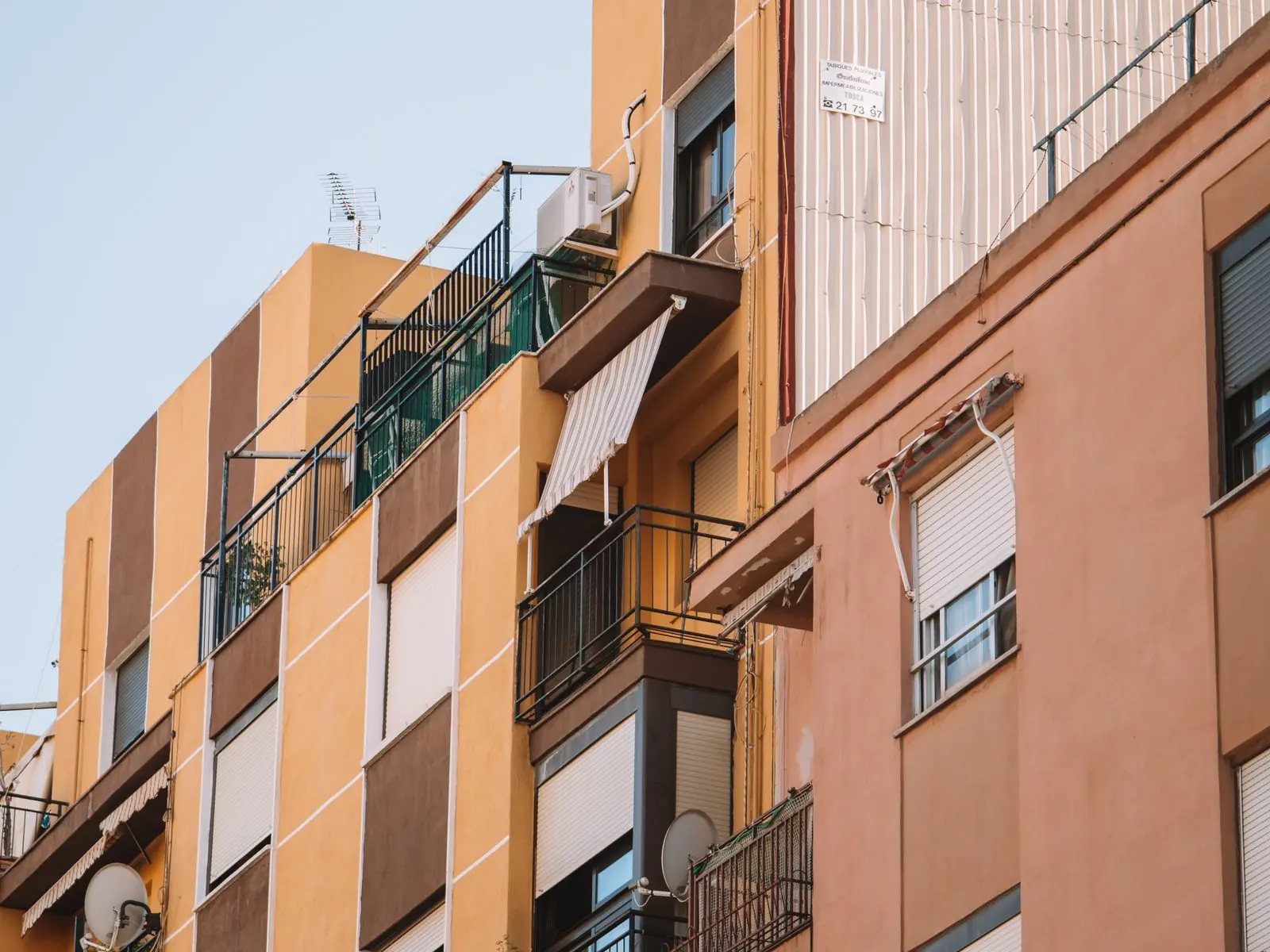 Fachada de un edificio de viviendas con balcones y toldos